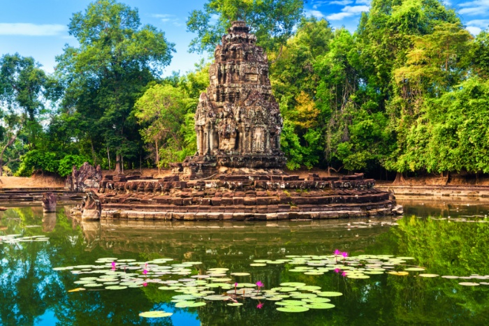 Ancient stone stupa of Neak Pean temple surrounded by a lake with water lilies in Angkor Siem Reap Cambodia