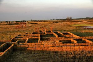 Straw bale walls and rural structures in a field in Banteay Meanchey Cambodia at sunset