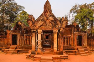 Intricate red sandstone carvings and devata lady statues at Banteay Srei temple in Siem Reap Cambodia