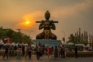 The giant black Ta Dumbong statue at the main roundabout in Battambang Cambodia at sunset