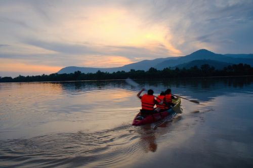 Tourists in life jackets kayaking on the Preak Tuek Chhu River in Kampot at sunset