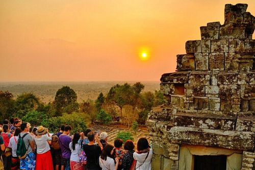 Tourists watching the golden sunset at Pre Rup temple mountain in Siem Reap Cambodia