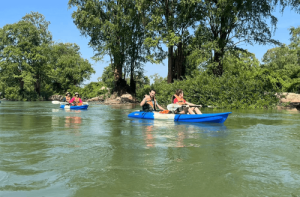 Tourists kayaking on the Mekong River in Kratie to see Irrawaddy dolphins; book your trip with Phnom Penh Taxi Drive.