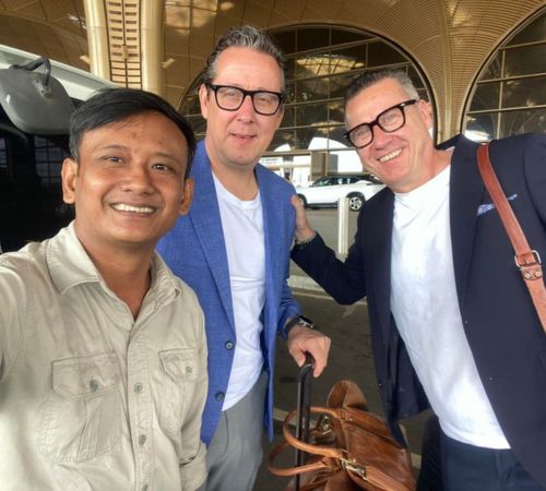 Friendly English-speaking Phnom Penh taxi driver with happy tourists at the airport.